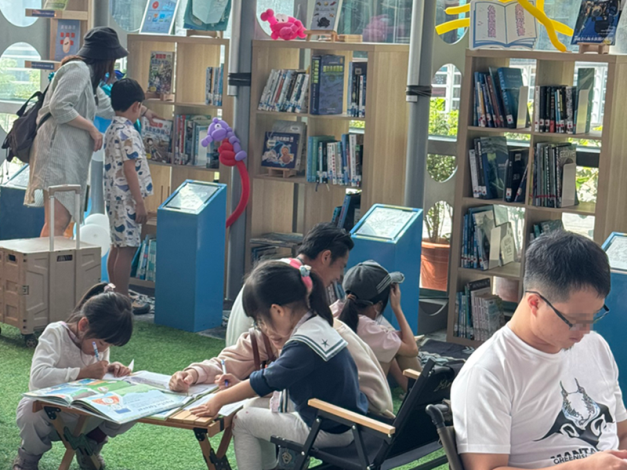 圖4 大小朋友坐在好書閱讀區草地上閱讀，留下讀書心得